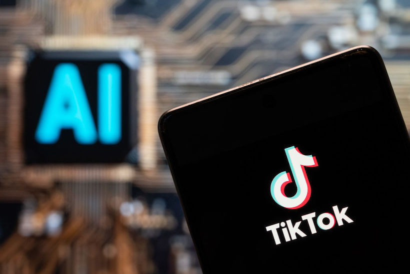 Smart phone displaying TikTok logo with AI logo in background