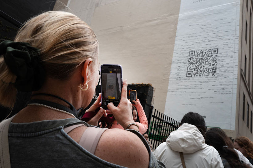 Taylor Swift fans gather outside a building where a mural featuring a large QR code was being painted to promote Swift's latest album, "The Tortured Poets Department."