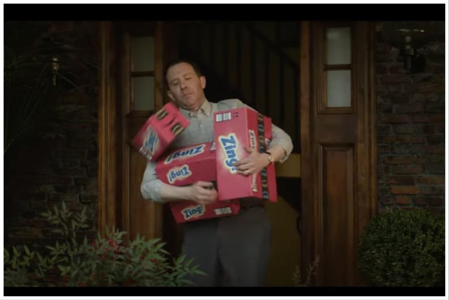 A man with an armful of boxes on his doorstep