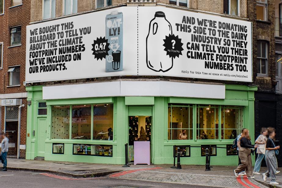 Oatly billboard above green shop front.