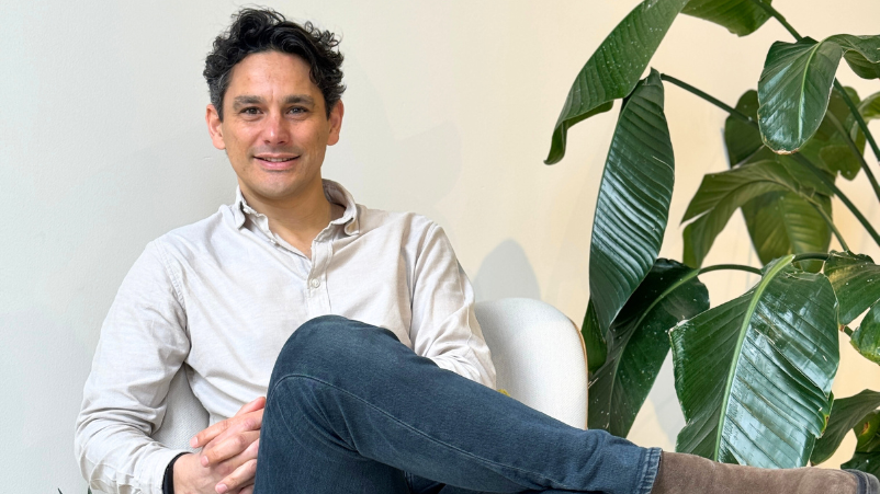 Man sitting on chair next to a plant